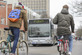 Zwei radelnde Personen fahren am Campus Süd dem KIT Shuttlebus entgegen